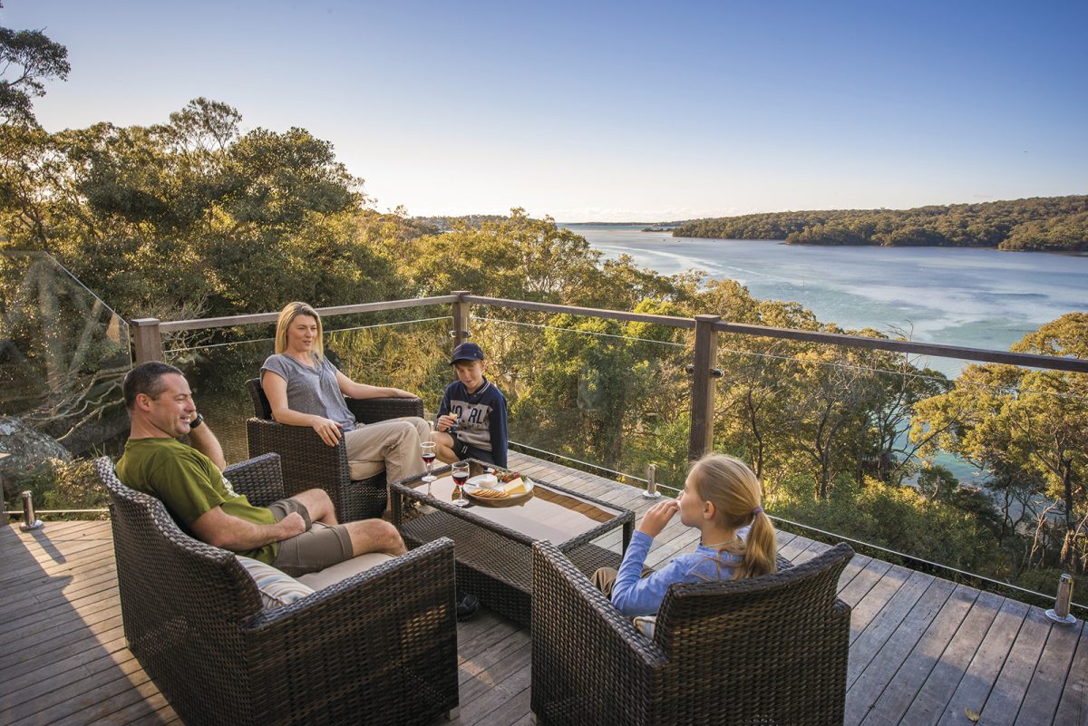 A family of four on the deck of Hilltop cottage, Royal National Park. Photo: John Spencer/DPIE