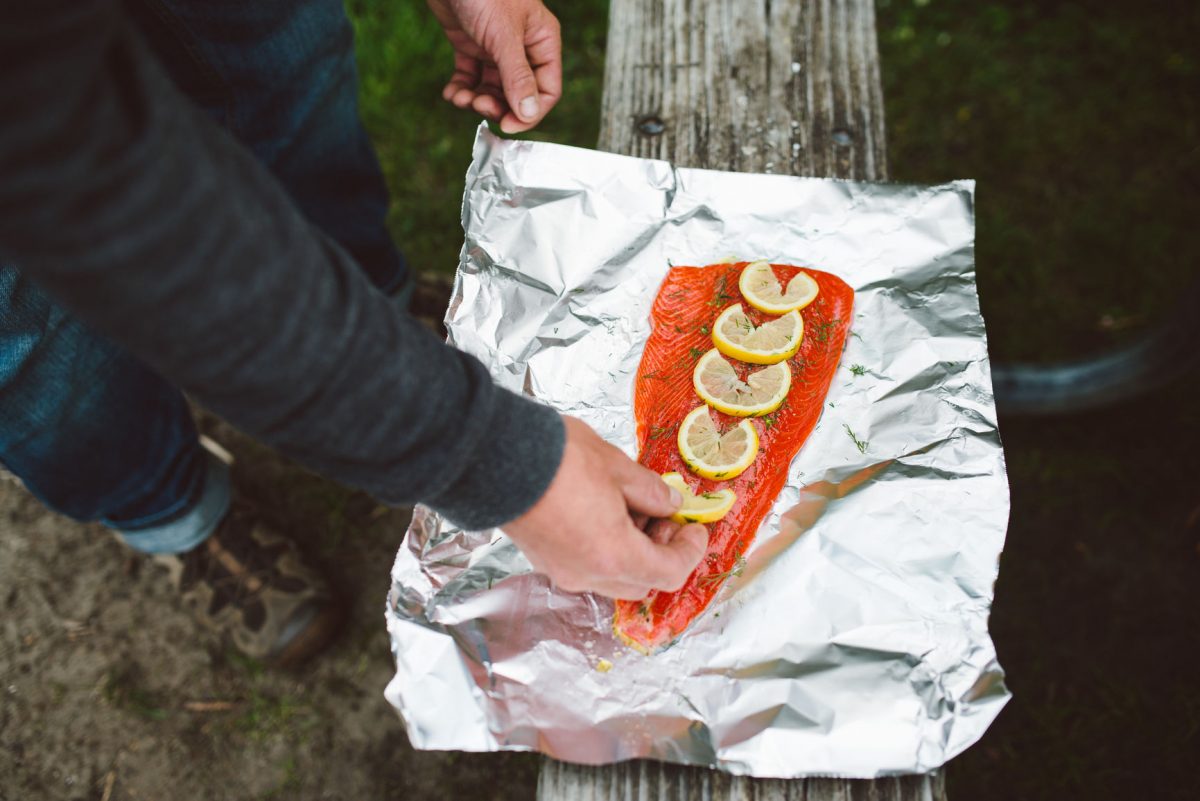 Preparing a piece of fish with lemon to be placed on the barbecue