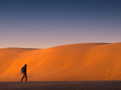 Man in front of large red sand dunes, Mungo National Park. Photo: Matt Donovan