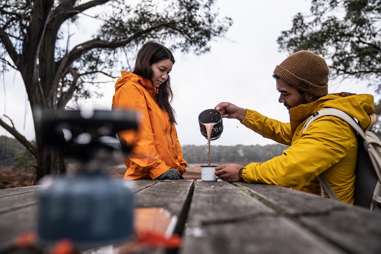 Two people pouring a drink in Barrington Tops National Park. Photo credit: Rob Mulally/DPIE