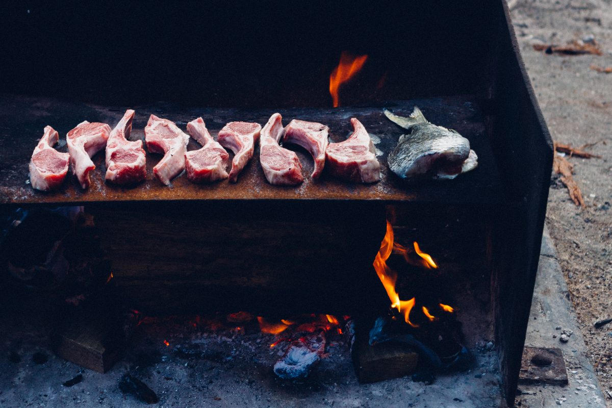 Meat and fish cooking on a campground barbecue. Photo: Jack Brookes