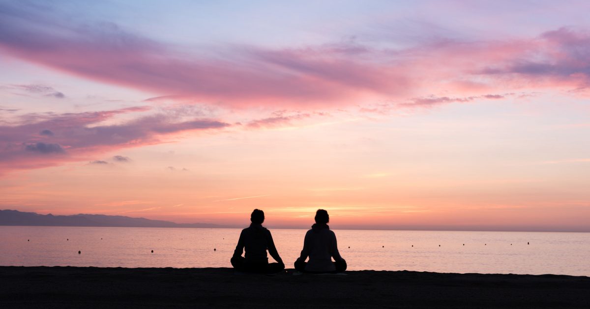 Two people meditating by the ocean. Photo: Seb Ruiz