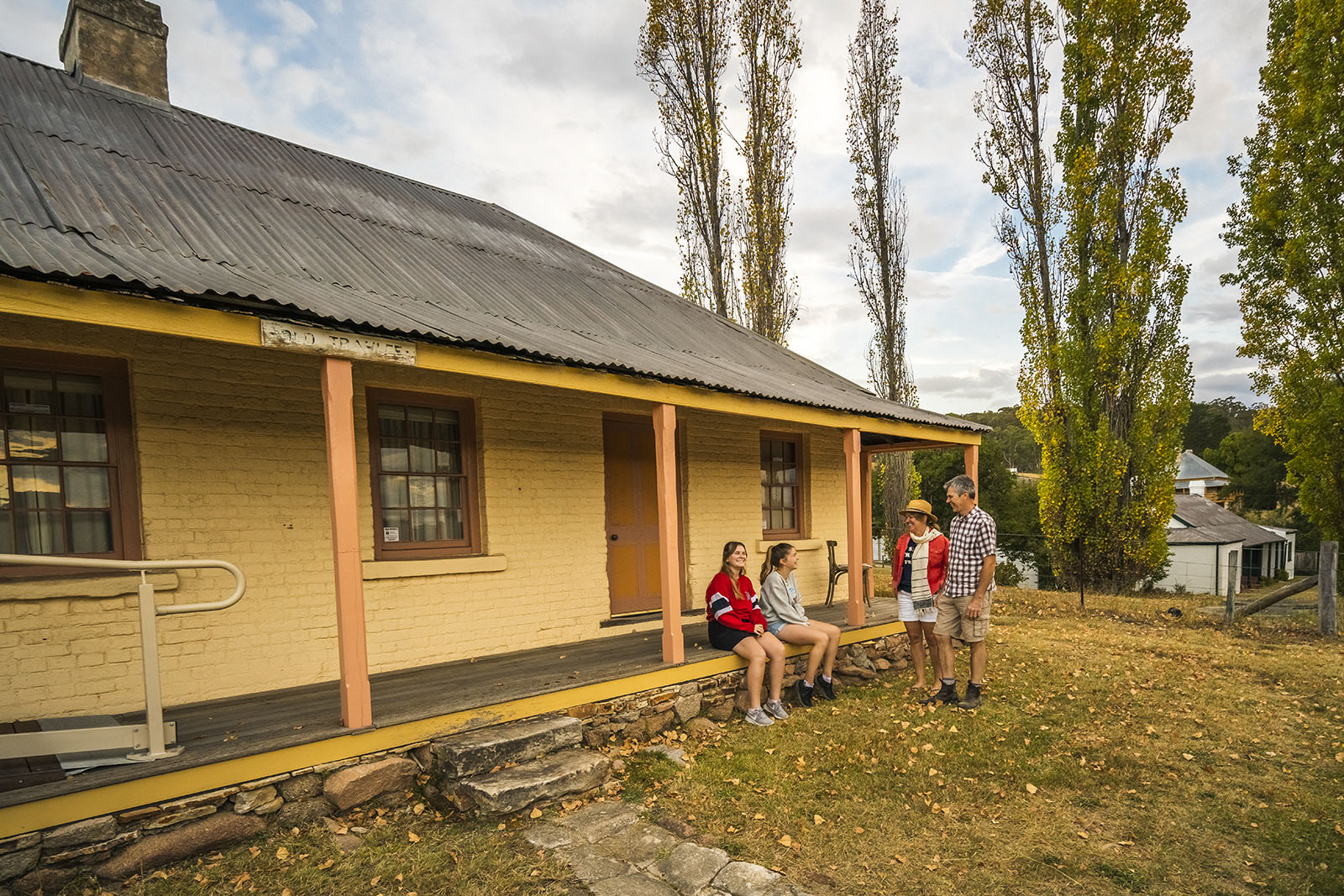 A family sitting outside Old Trahlee, Hartley Historic Site. Photo: John Spencer/DPIE