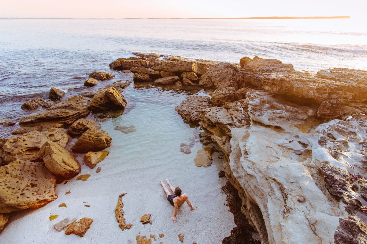 Person relaxing in a rock pool, Jervis Bay National Park. Photo: Tim Clark