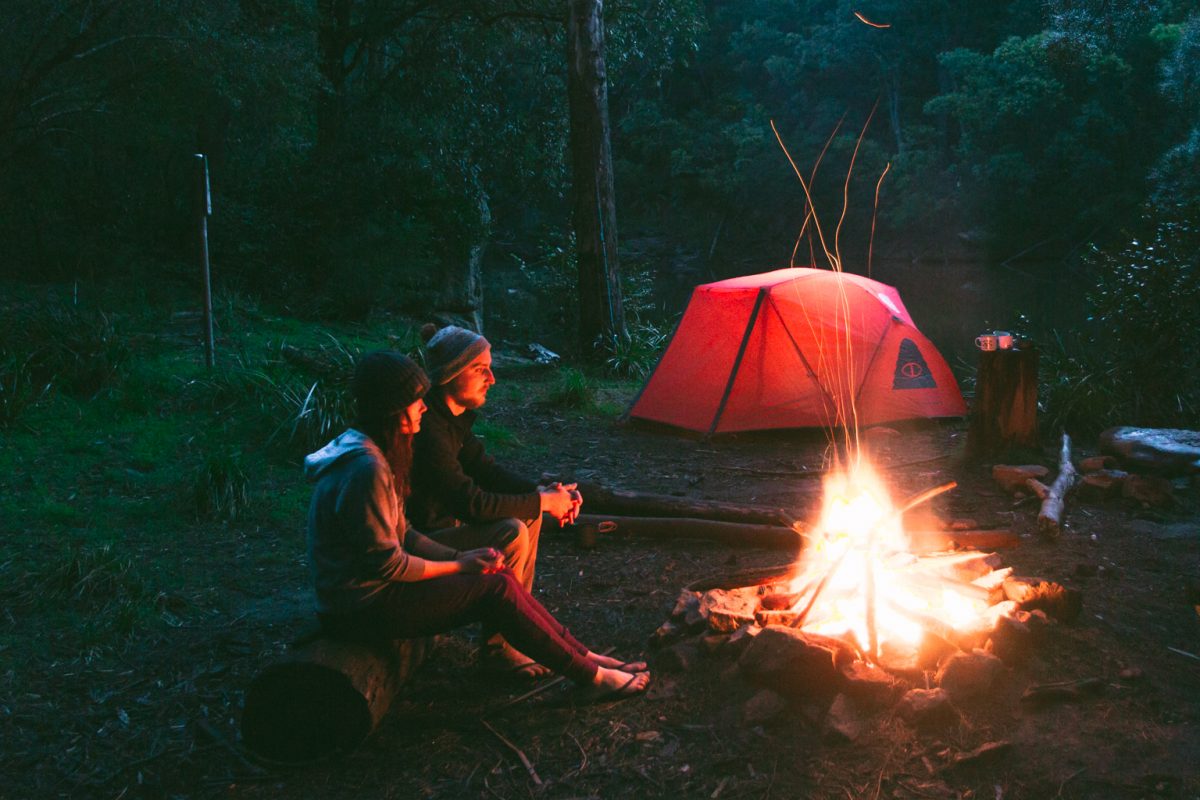 Two people sitting by a campfire at a NSW national park campground, Morton National Park. Photo: Tim Clark