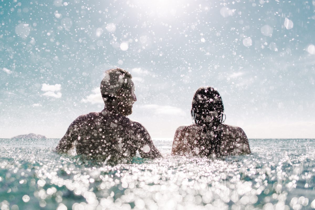Couple swimming at the beach on a sunny day, Tomaree National Park. Photo: Tim Clark