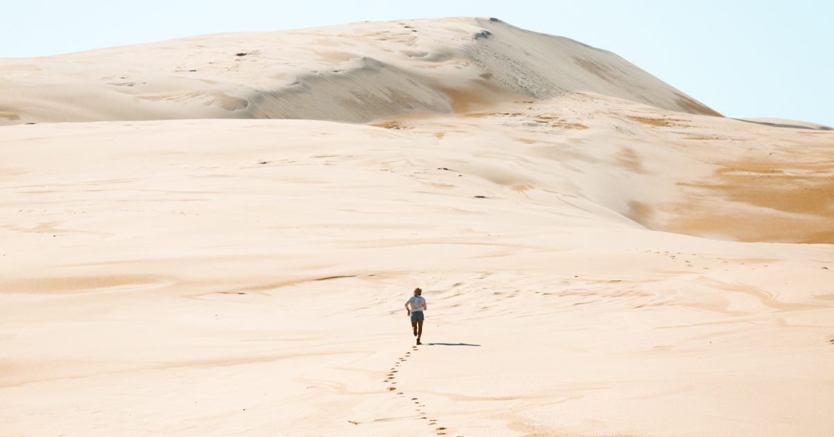 Person running up the Stockton sand dunes, Worimi National Park. Photo: Tim Clark