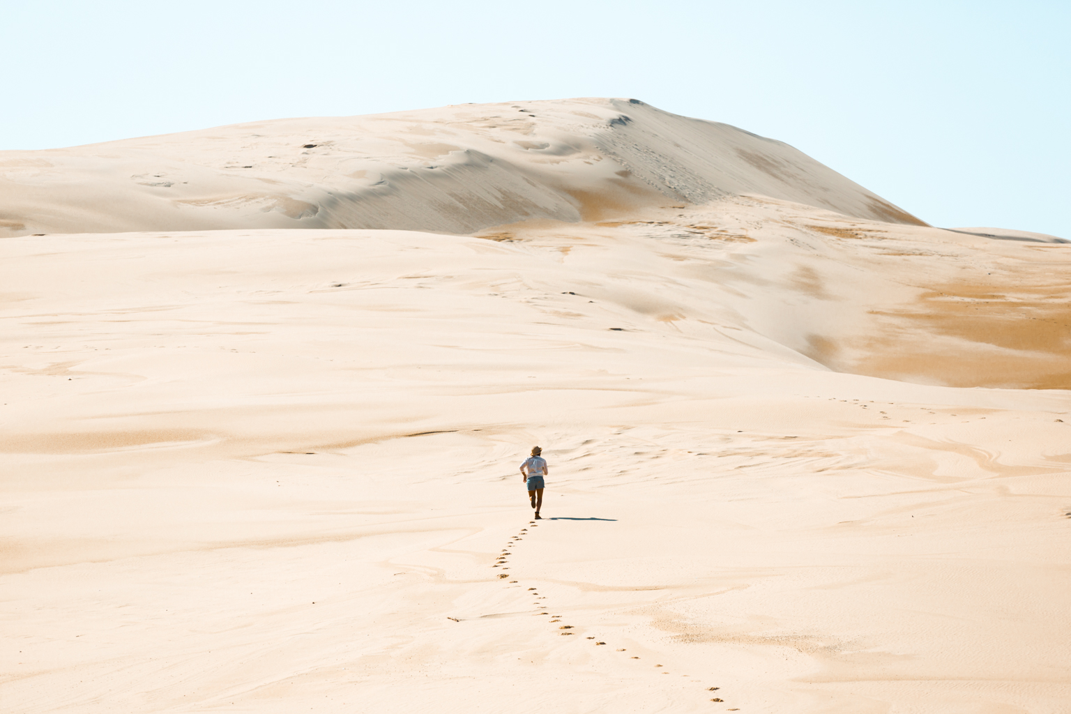 Person running up the Stockton sand dunes, Worimi National Park. Photo: Tim Clark
