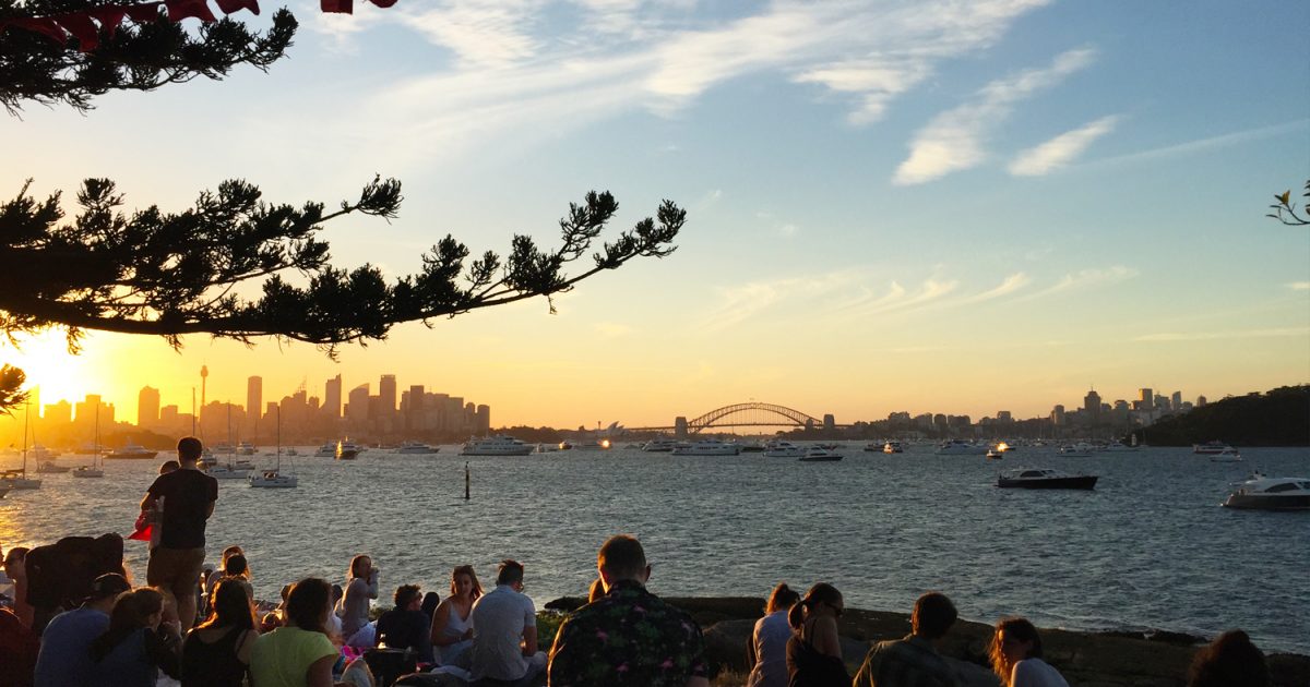 People relaxing at sunset before the Sydney Harbour New Year's Eve fireworks at Shark Island, Sydney Harbour National Park. Photo: Matthew Mannall