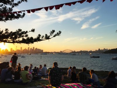 People relaxing at sunset before the Sydney Harbour New Year's Eve fireworks at Shark Island, Sydney Harbour National Park. Photo: Matthew Mannall