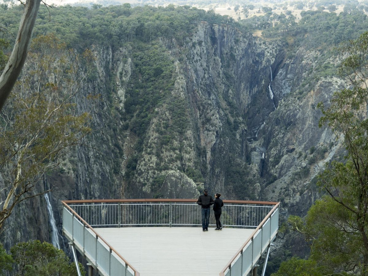 Two people at the Wollomombi Falls and Chandler Falls lookout. Photo: Leah Pippos/DPIE