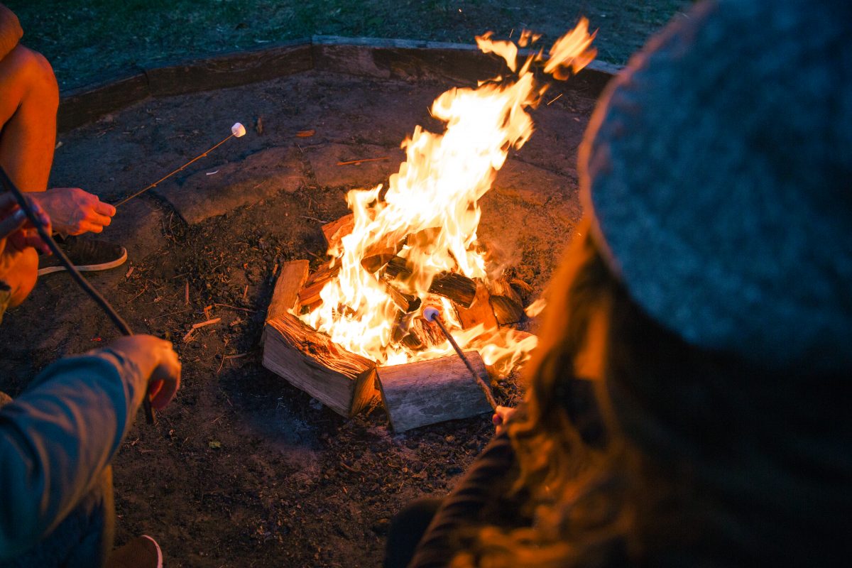 People toasting marshmallows around a fire at The Basin campground in Ku-ring-gai Chase National Park. Photo: Tim Clark