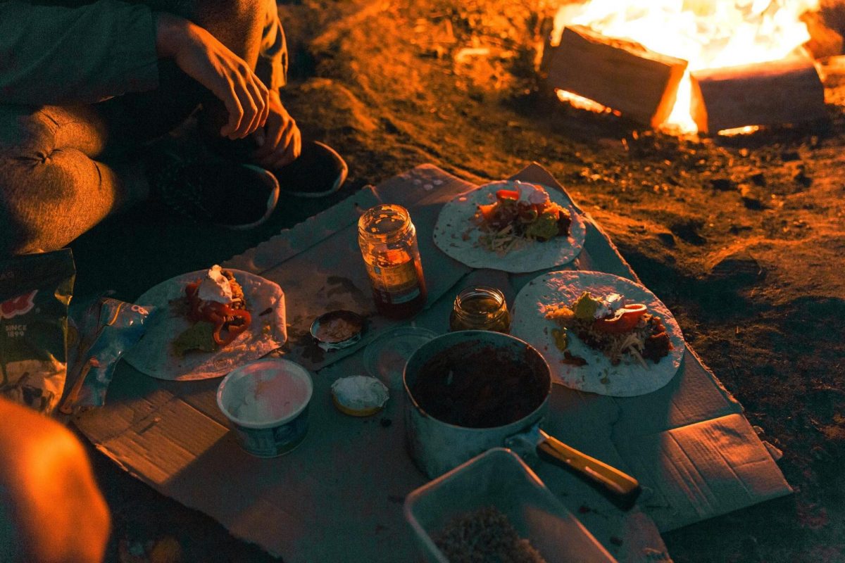 Group of people eating around a campfire at The Basin campground in Ku-ring-gai Chase National Park. Photo: Tim Clark/DPIE