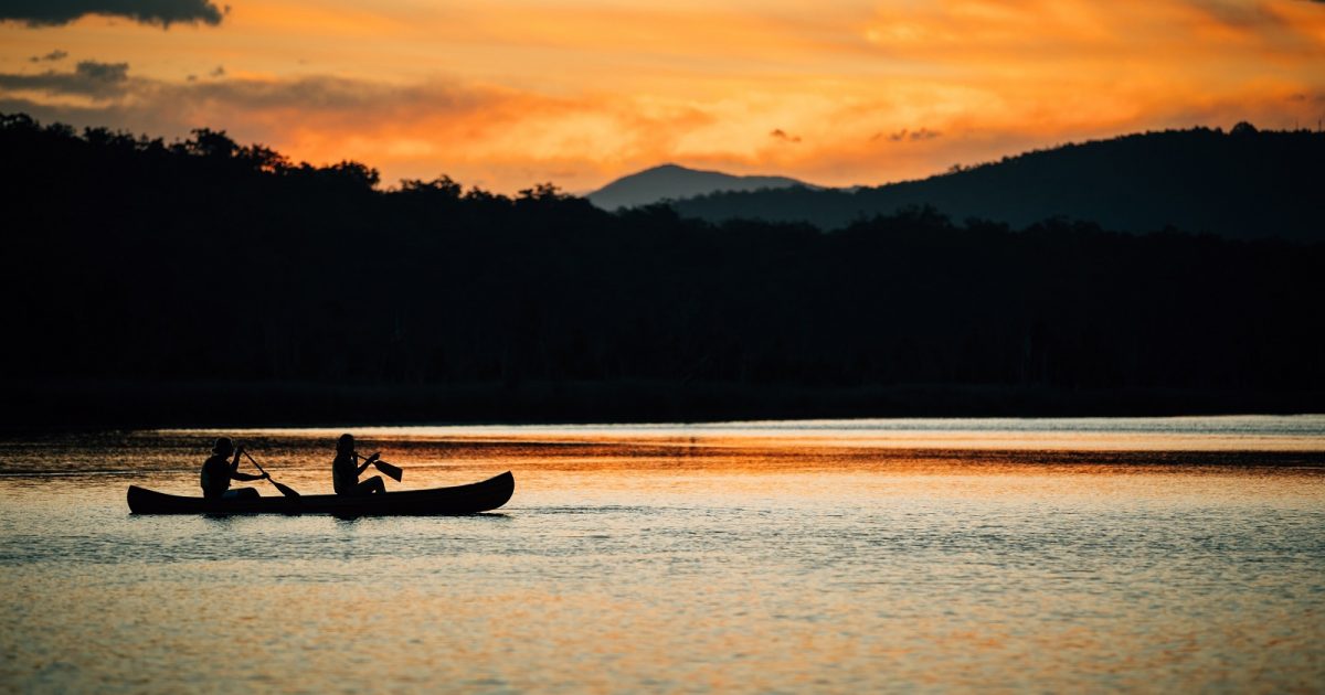 Two people canoeing at sunset in Murramarang National Park. Photo: Melissa Findley/DPIE