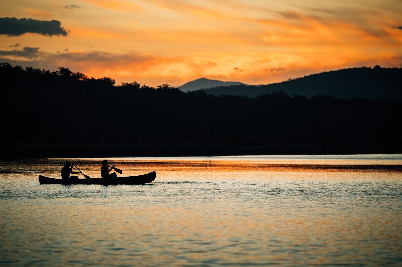 Two people canoeing at sunset in Murramarang National Park. Photo credit: Melissa Findley/DPIE