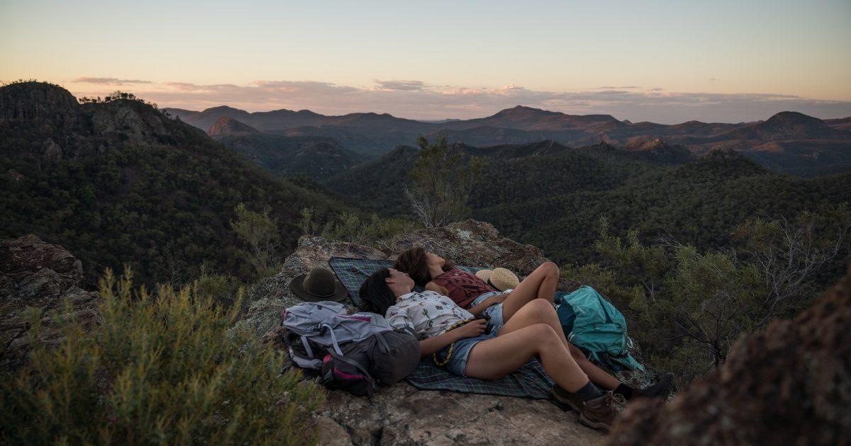 Couple relaxing at sunset in Warrumbungle National Park. Photo: Robert Mulally/DPIE