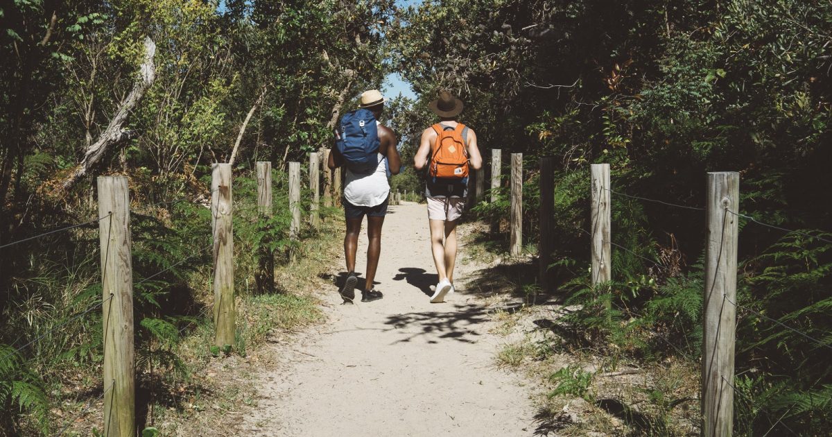 Two guys walking down a track towards the beach in Tomaree National Park. Photo credit: Erin McGauley/DPIE
