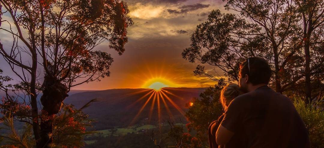 Two people sitting at Monkey Face lookout in Watagans National Park. Photo: Matthew Landesmann
