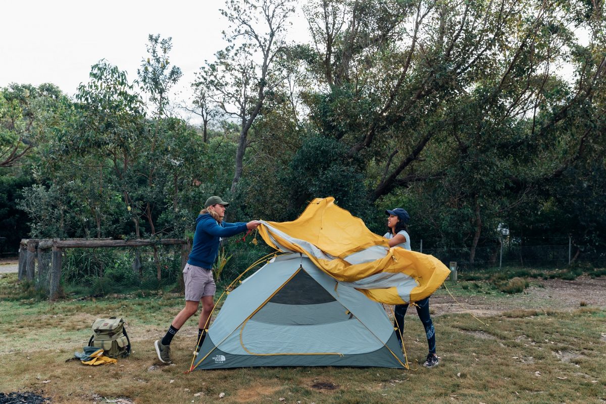 A woman and man setting up the tent at Pretty Beach campground. Photo credit: Melissa Findley/DPIE