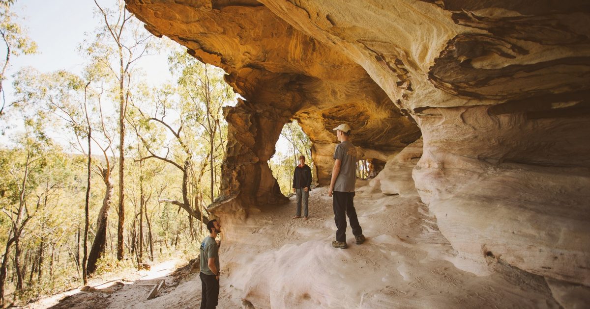 Three men in the Sandstone Caves at Pilliga Nature Reserve. Photo Credit: Harrison Candlin / DPIE