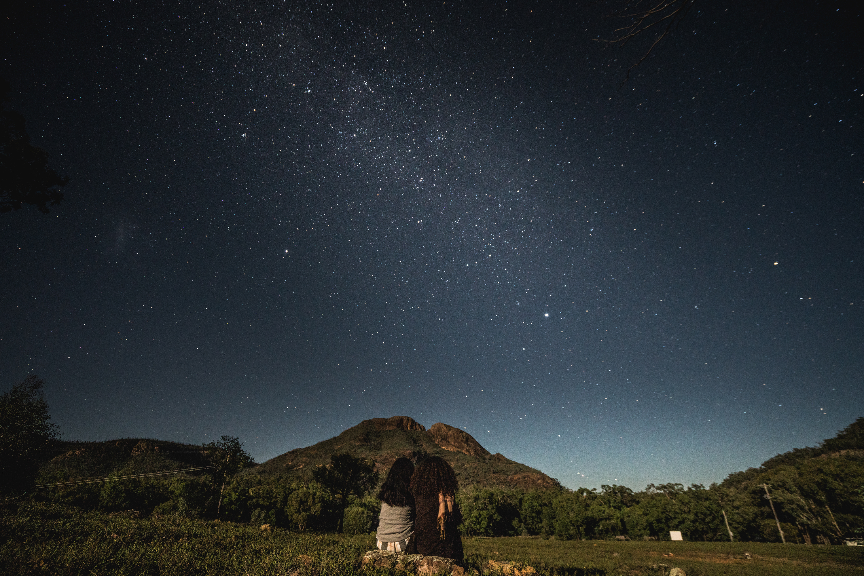 Two people looking at the night sky in Warrumbungles National Park. Photo credit: Rob Mulally/DPIE