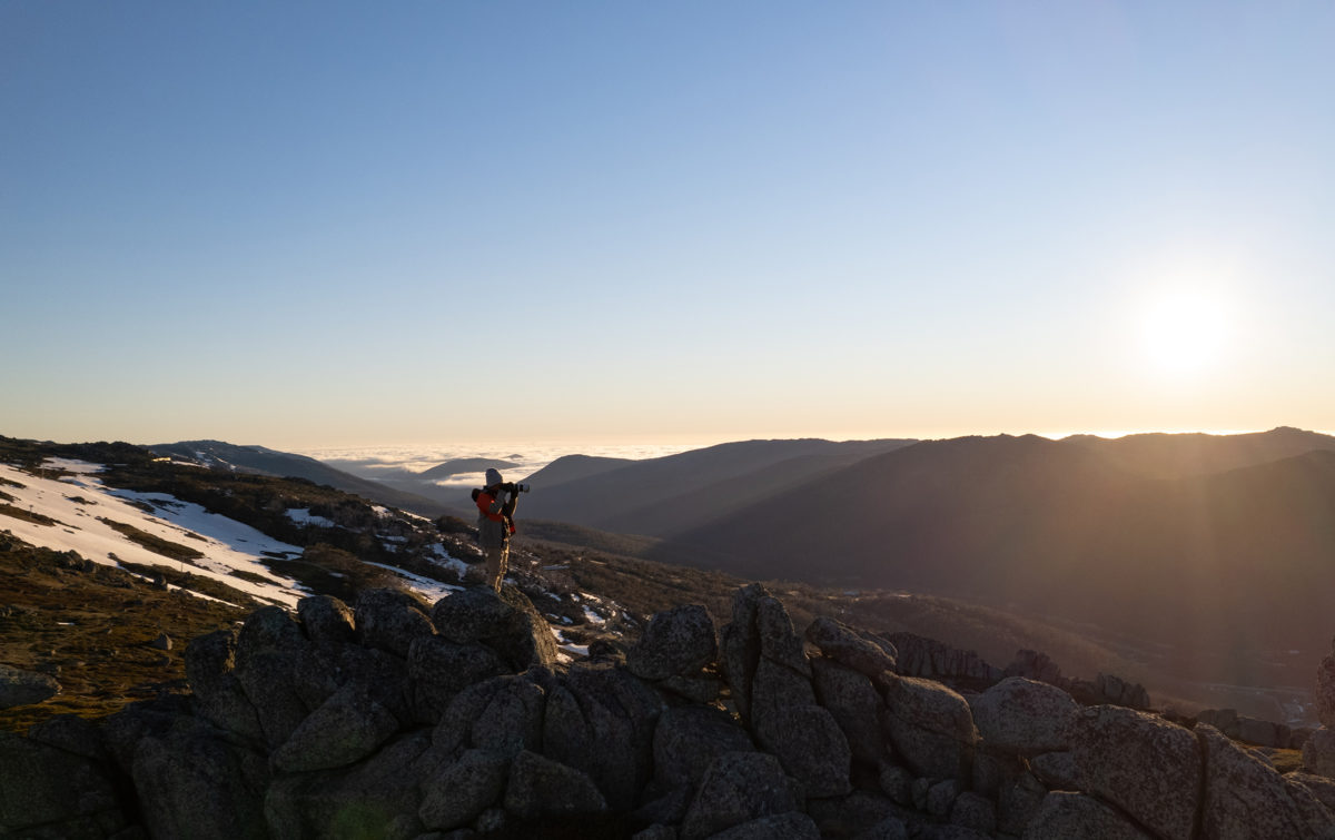 A man taking a photo of the sunset in Kosciuszko National Park. Photo: Jimmy Mellowes