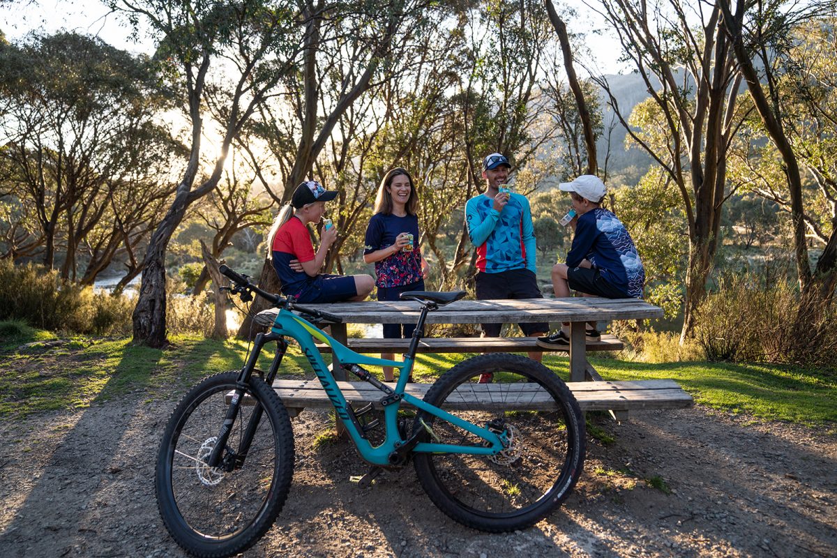Family of four enjoying poppers at a picnic table in Thredbo Diggings campground