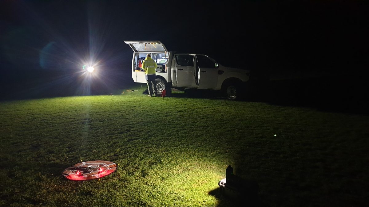 NSW National Parks Drone pilot setting up a drone under light from his vehicle at night. Photo: Scott / DPIE