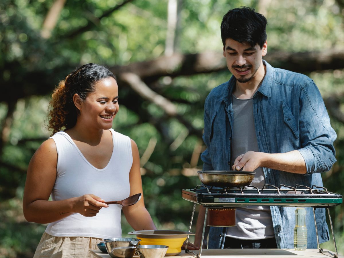 Two people cooking on a camp stove. Photo: Uriel Mont via Pexels
