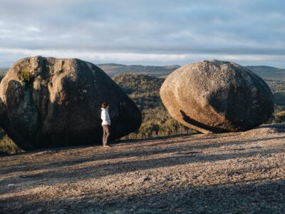 A person standing next to boulder on top of Bald Rock summit for sunrise, Bald Rock National Park. Photo: Harrison Candlin © Harrison Candlin / DPE