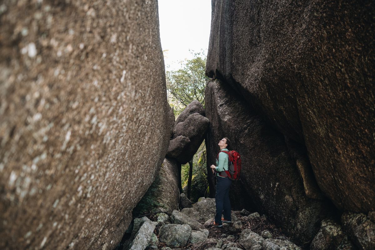 Standing in a rocky chasm at Woollool Woolloolni Aboriginal Place. Photo: Harrison Candlin © Harrison Candlin / DPE