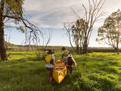 A family of four carrying a canoe in Murray River National Park. Photo:Boen Ferguson