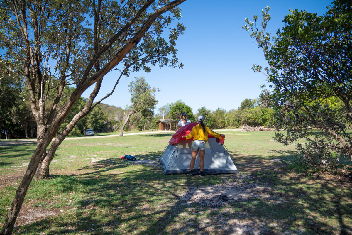 Two people setting up a tent in Kylies Beach campground. Photo credit: Rob Mulally DPE