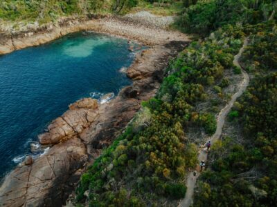 Aerial view of three people walking along Tomaree Coastal Walk, Boat Harbour, Tomaree National park. Photo credit: Remy Brand / DPE