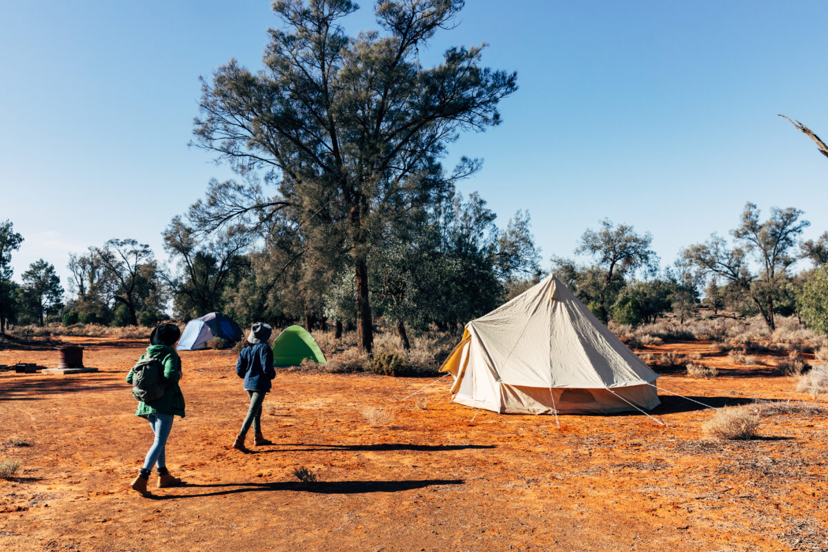 Two people walking towards their tent. Mungo National Park. Photo credit: Melissa Findley / DPE