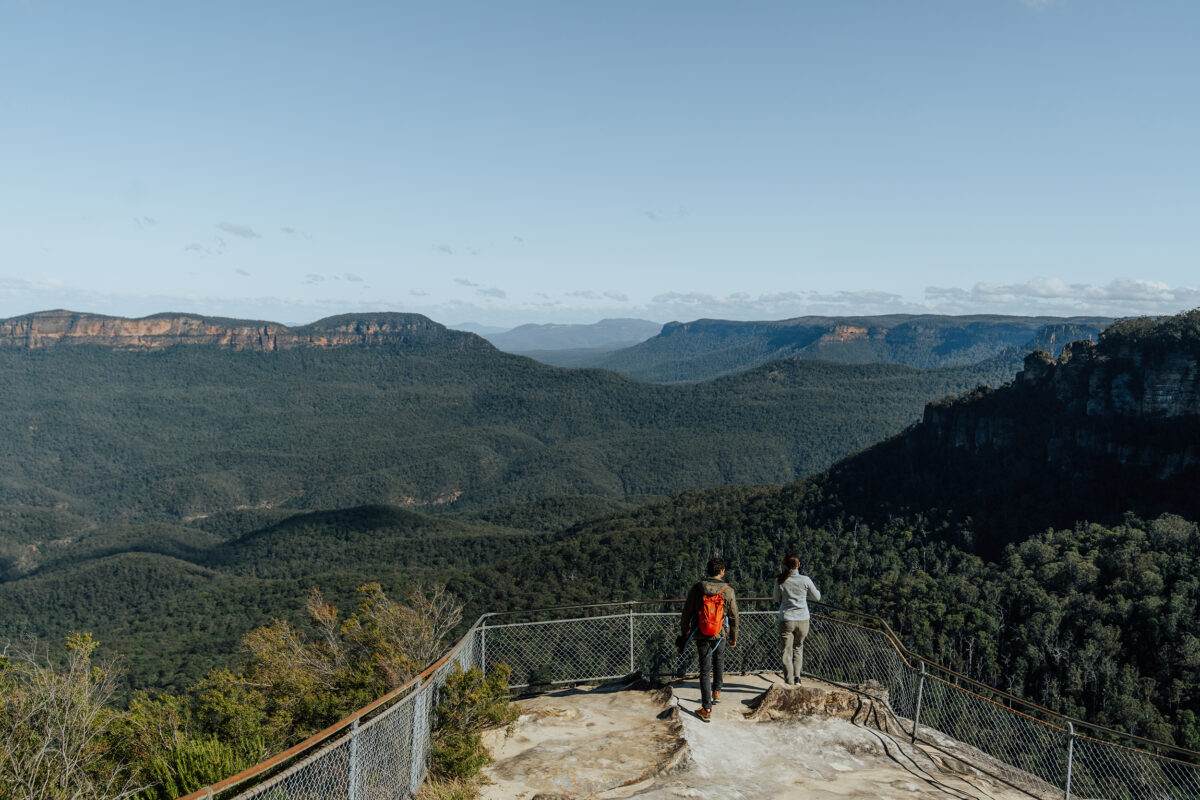 Two people at Olympian Rock lookout, Grand Cliff Top Walk, Blue Mountains National Park. Photo Credit: Remy Brand / DCCEEW