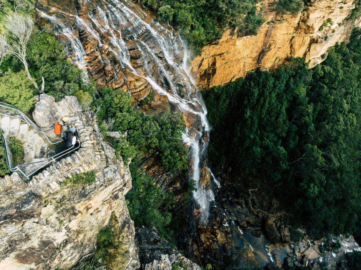 Aerial view of two people at Fletchers Lookout, Grand Cliff Top Walk,, Blue Mountains National Park. Photo Credit: Remy Brand / DCCEEW