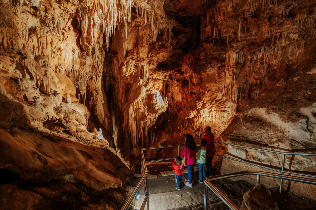 A family of four admiring the inside of Fig Tree cave, Wombeyan Caves, Wombeyan Karst Conservation Area. Photo credit: Remy Brand / DCCEEW