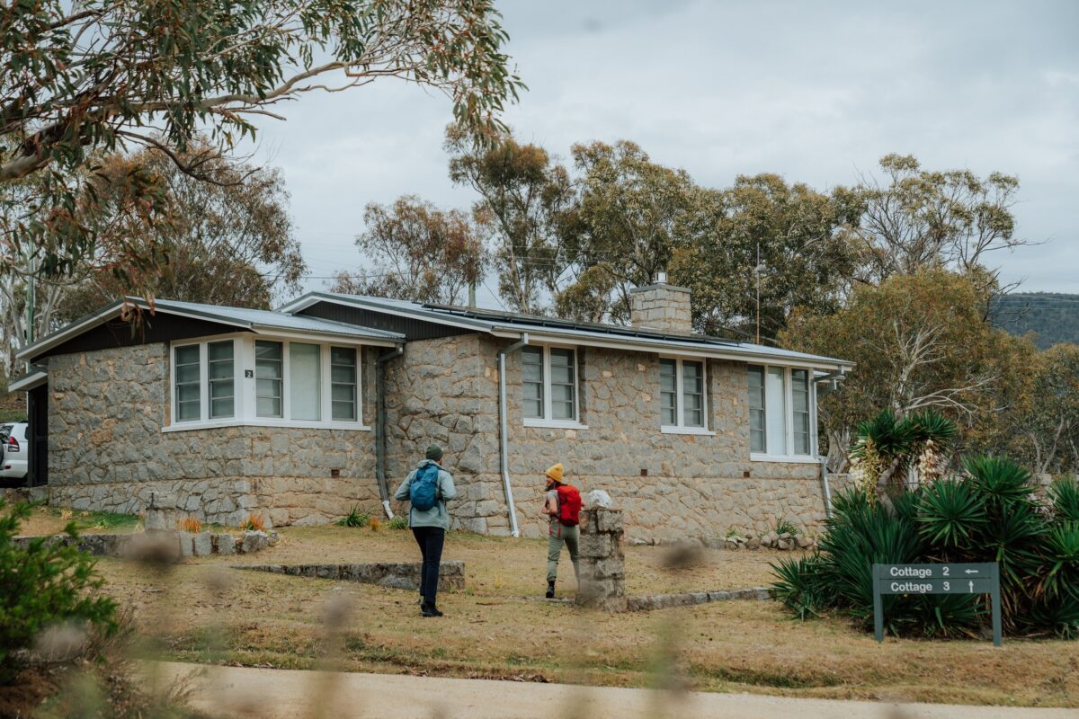Two walkers outside Creel Bay Cottages on the Snowies Alpine Walk. Photo credit: Remy Brand/DCCEEW