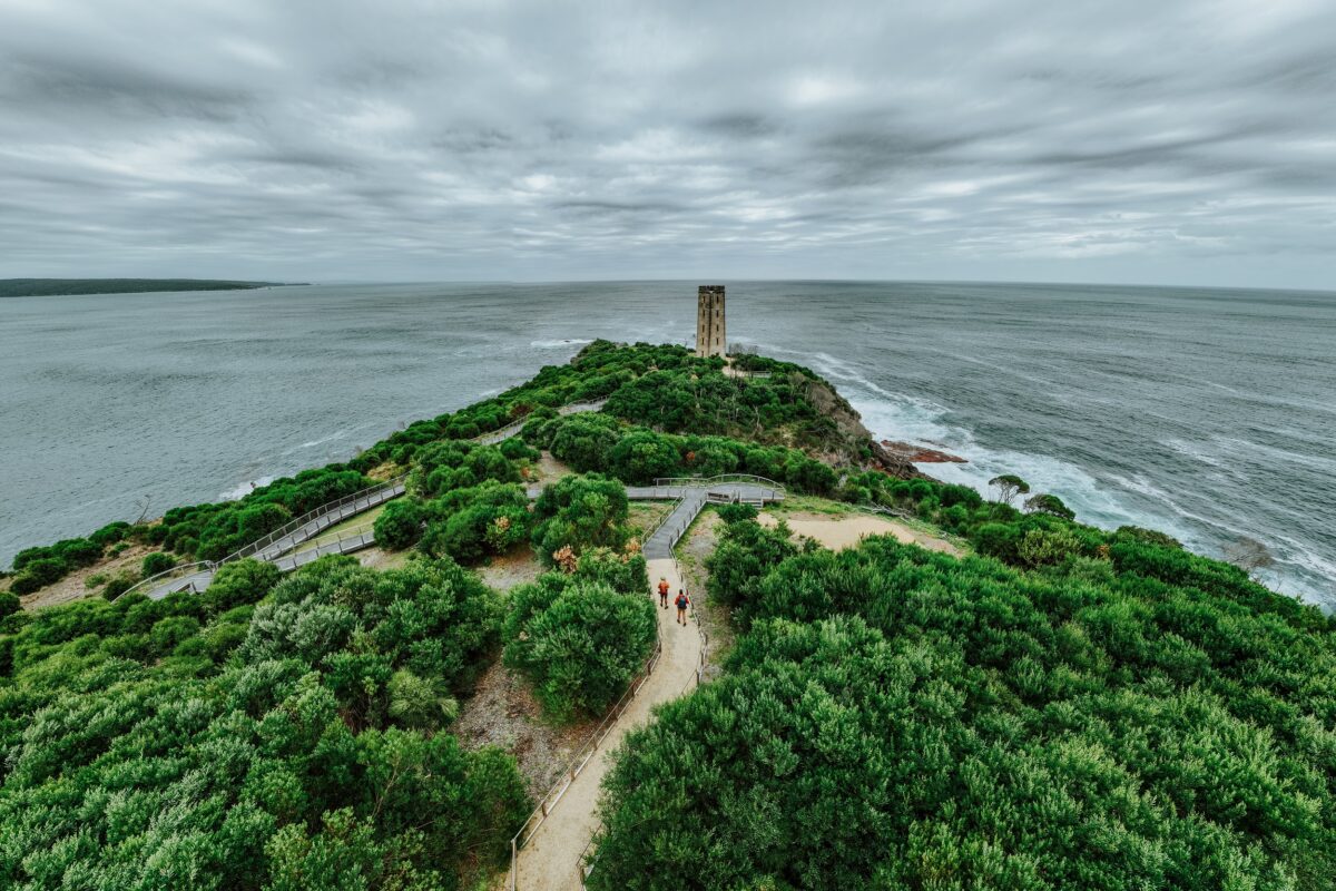 Two walkers at Boyds Tower on the Light to Light Walk. Photo credit: Daniel Parsons/DCCEEW