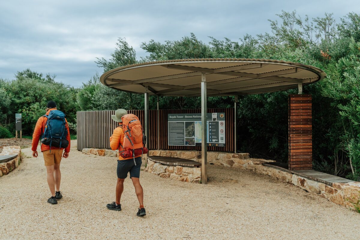 Two walkers at Boyds Tower on the Light to Light Walk. Photo credit: Remy Brand/DCCEEW