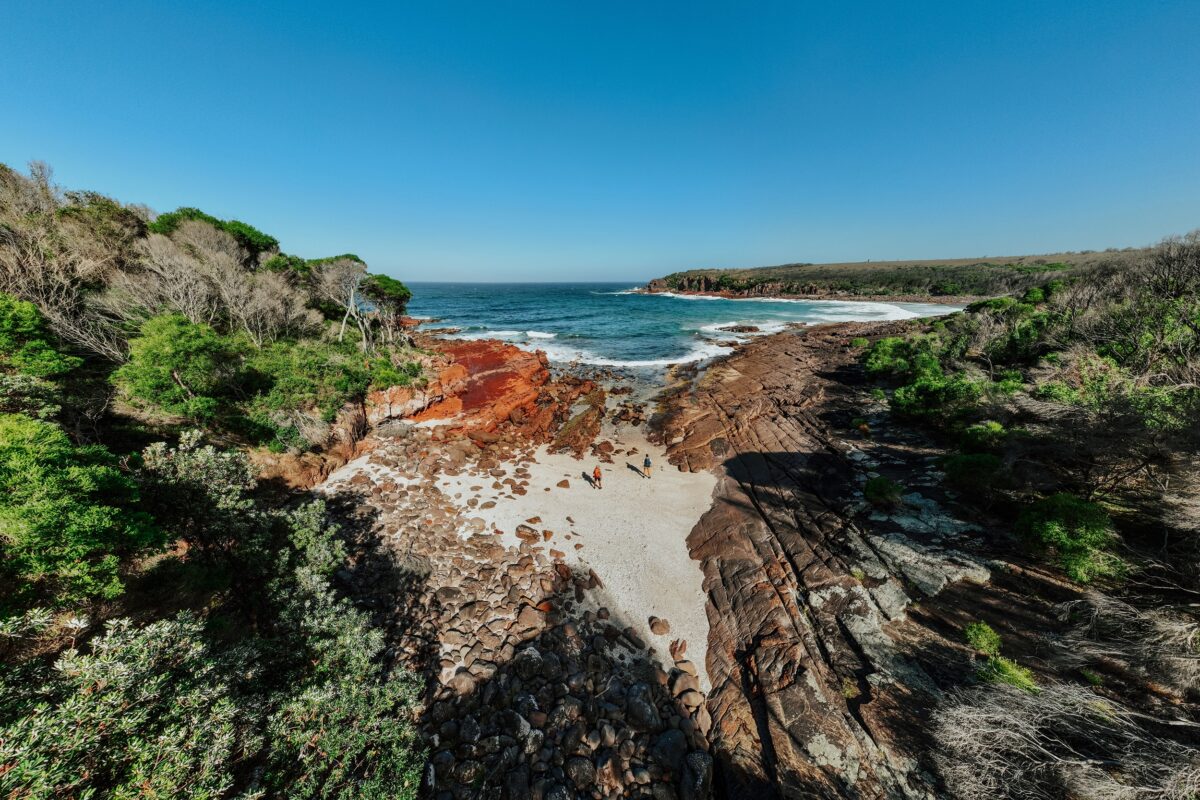 Two walkers at Hegartys Bay on the Light to Light Walk. Photo credit: Daniel Parsons/DCCEEW