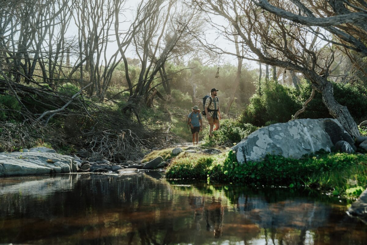 Two walkers at Hegartys Bay on the Light to Light Walk. Photo credit: Remy Brand/DCCEEW