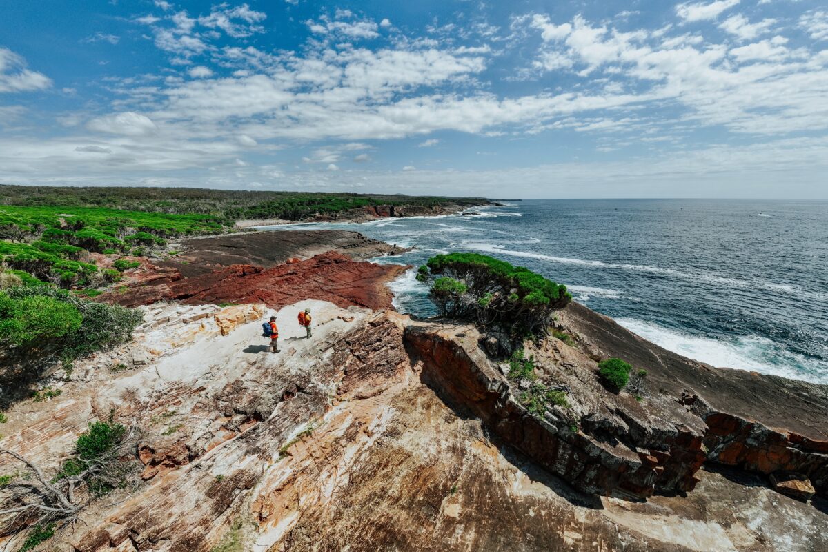 Two walkers take in the view from Pulpit Rock on the Light to Light Walk. Photo credit: Daniel Parsons/DCCEEW