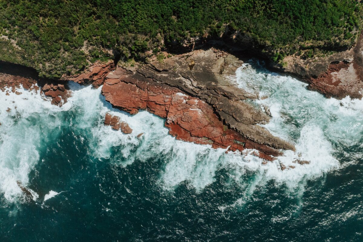An aerial view of red rock cliffs at Saltwater Creek on the Light to Light Walk. Photo credit: Daniel Parsons/DCCEEW