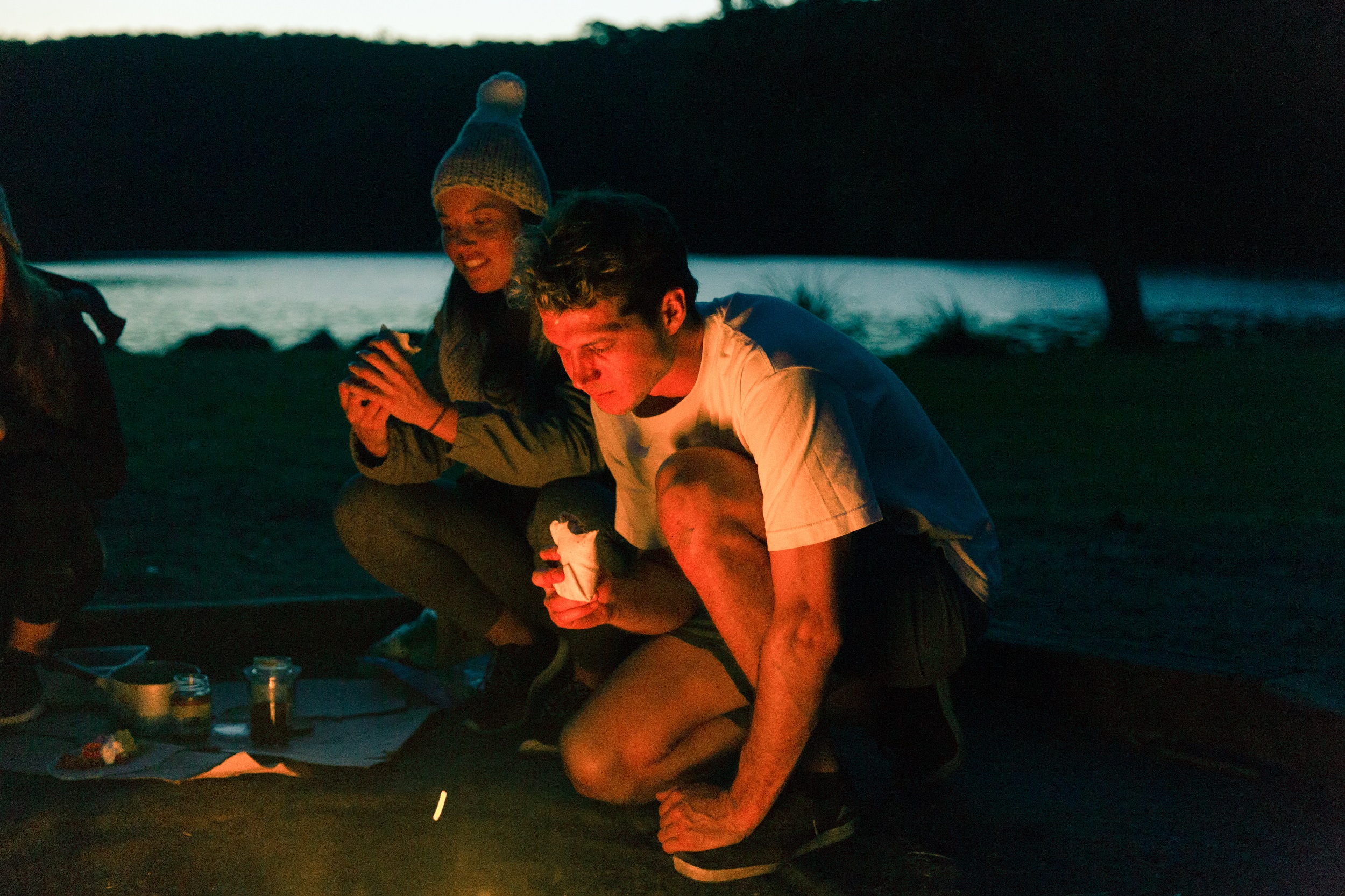 Campers eating dinner by the campfire. Photo credit: Tim Clark/DPE