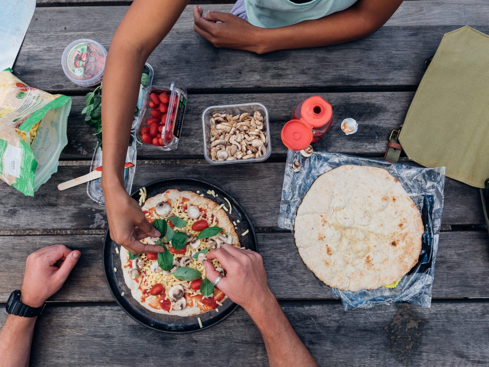 Campers preparing pizzas on a picnic table. Photo credit: Melissa Findley/OEH