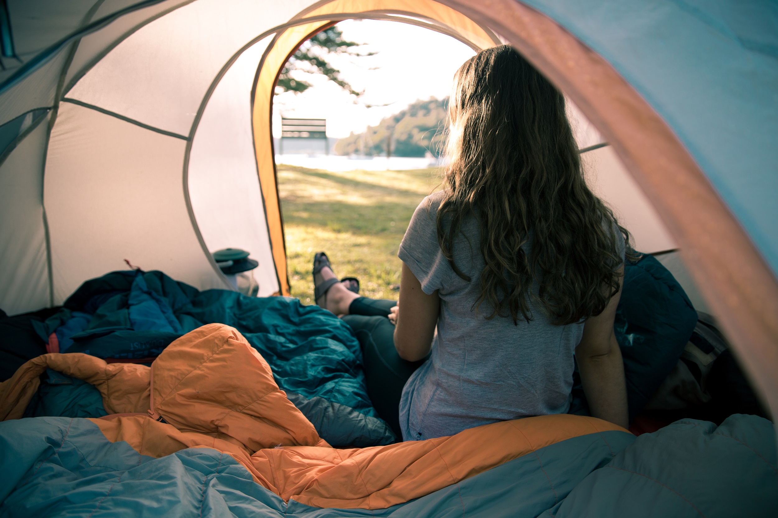Camper sitting inside their tent at The Basin campground.